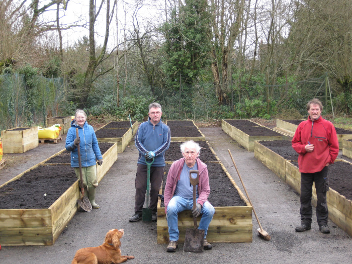Raised beds filled with with soil and the team that filled them